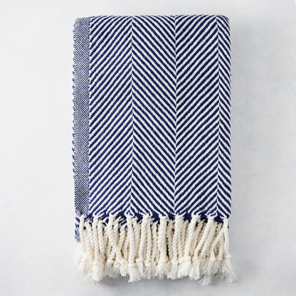Navy blue and white chevron cotton throw blanket with thick rope fringe.