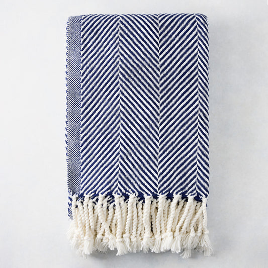Navy blue and white chevron cotton throw blanket with thick rope fringe.