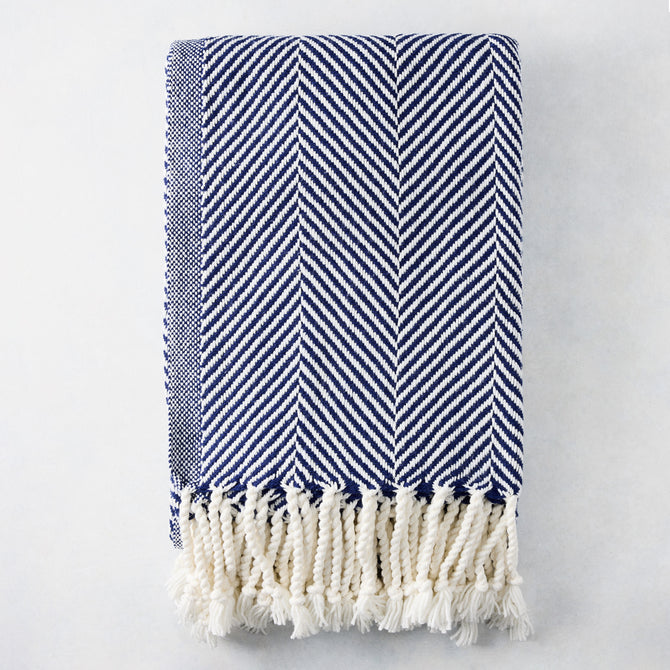 Navy blue and white chevron cotton throw blanket with thick rope fringe.