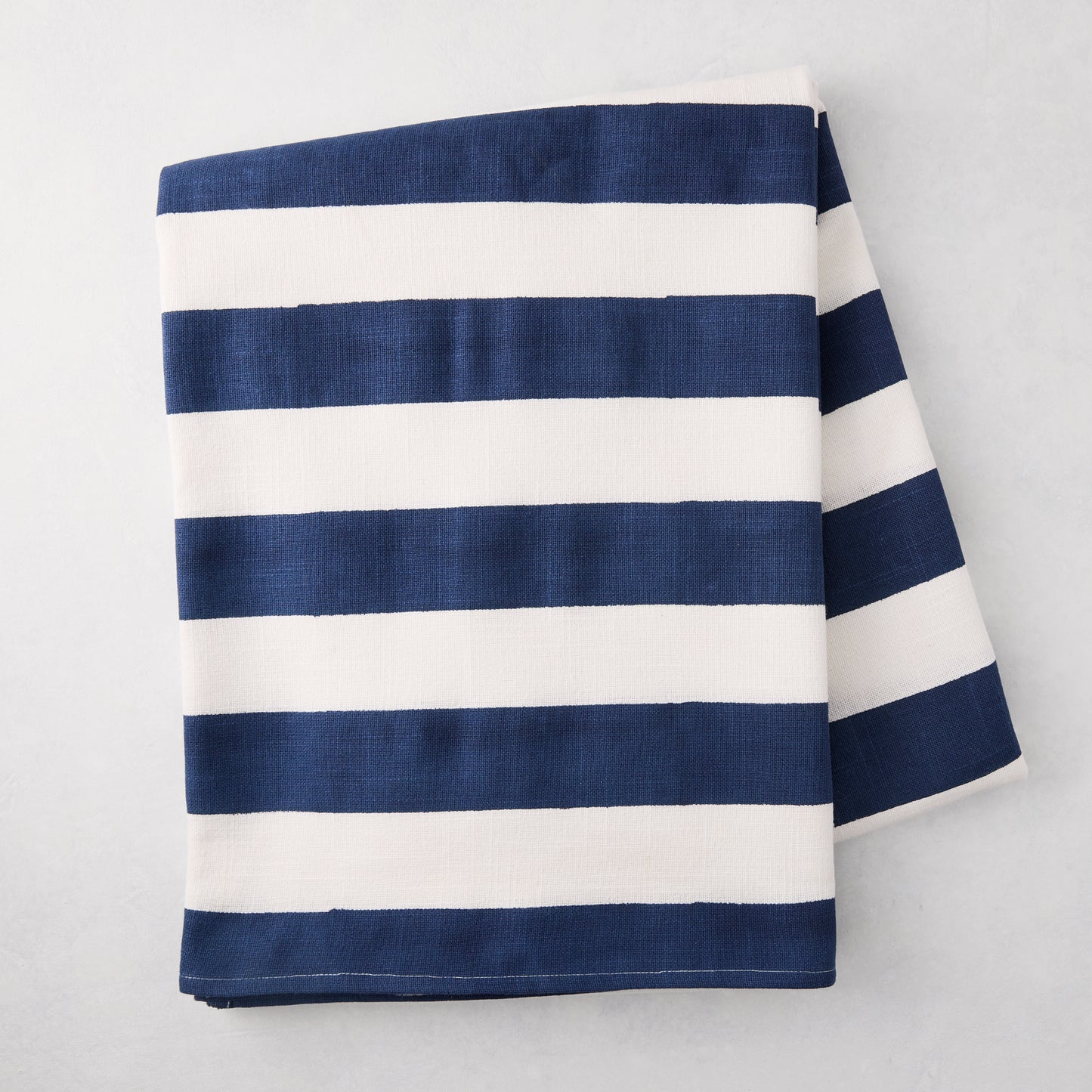 Navy Hampton Stripe Tablecloth, 100% cotton, folded, with bold navy and white horizontal stripes.