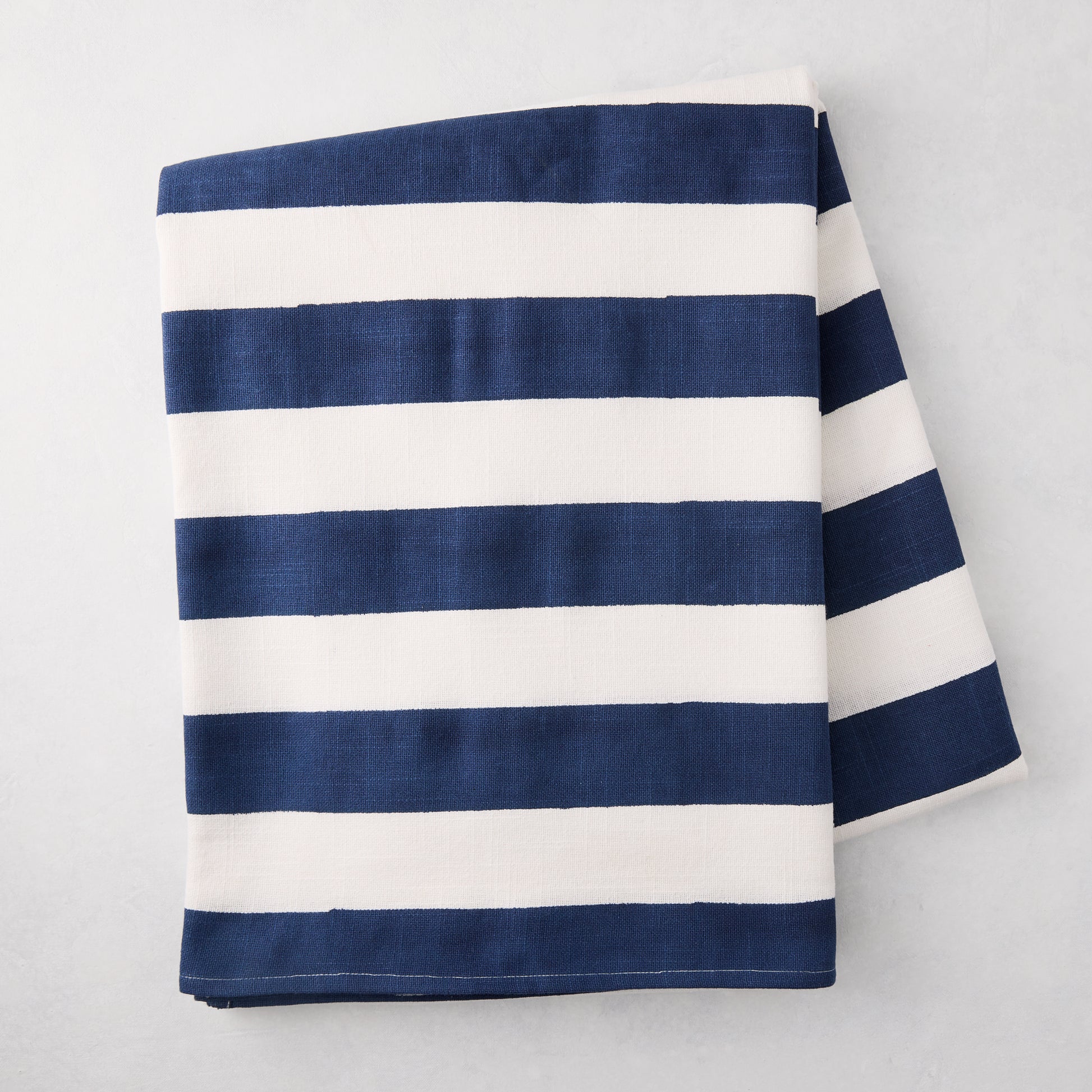 Navy Hampton Stripe Tablecloth, 100% cotton, folded, with bold navy and white horizontal stripes.