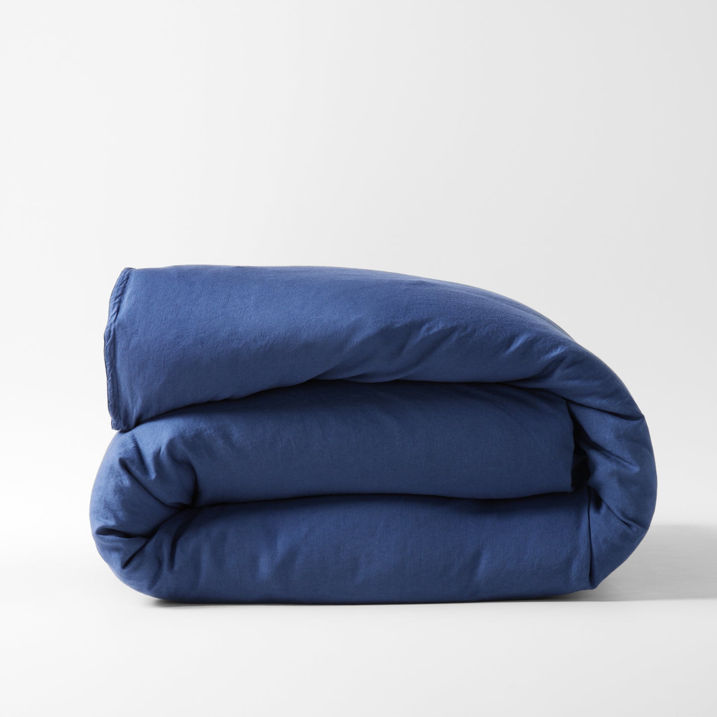 Folded navy blue washed linen duvet cover.