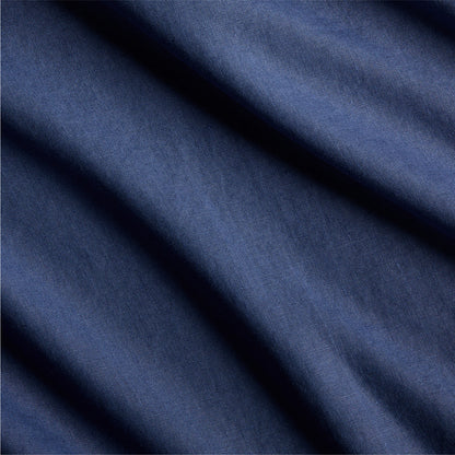Close-up of navy blue washed linen fabric with subtle texture and soft folds.