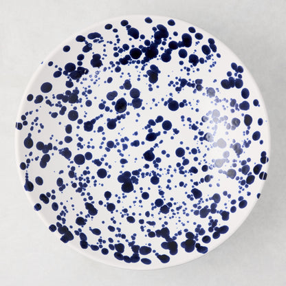 Navy blue splatter stoneware serve bowl, 12" diameter, white with hand-splattered navy dots.