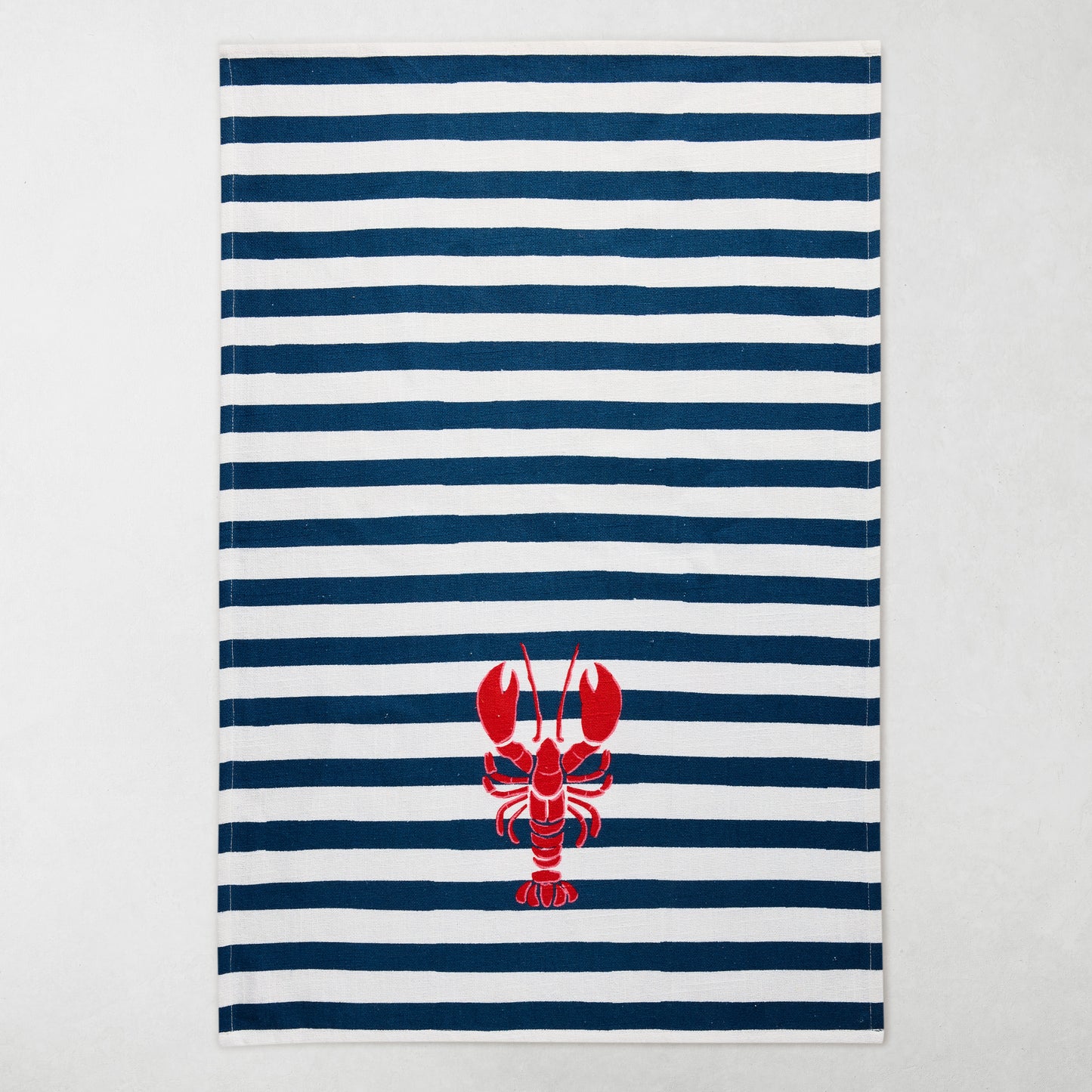 Navy and white striped cotton hand towel with a red lobster design.