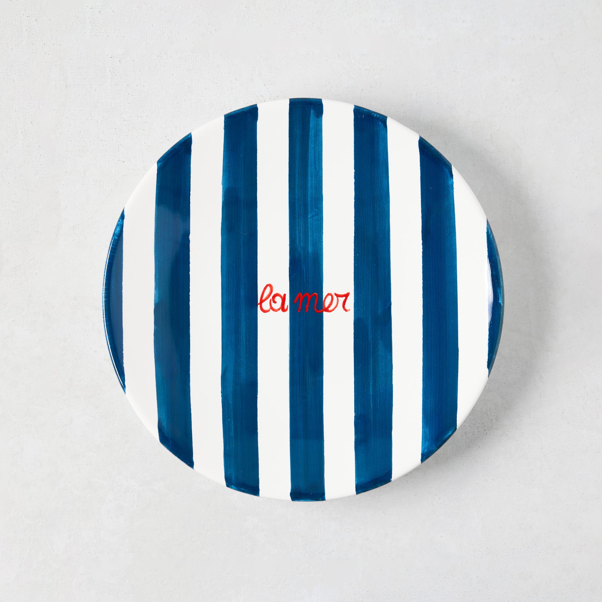 Hand-painted Italian ceramic appetizer plate with navy blue stripes and red "La Mer" text.