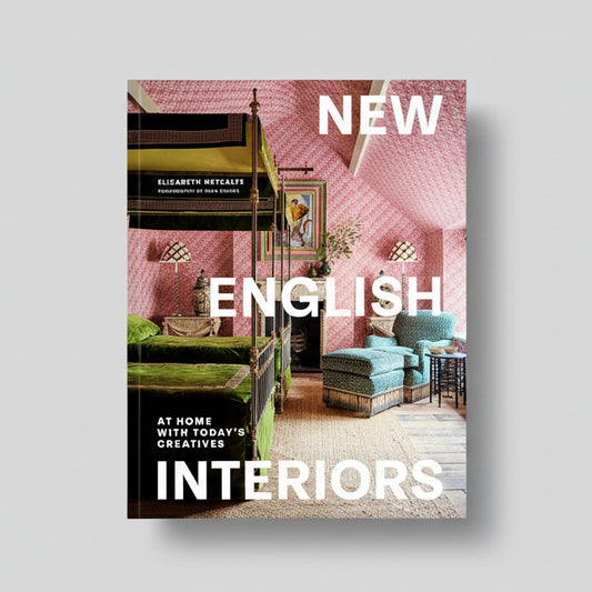 Hardcover book "New English Interiors" with a pink patterned room and green velvet bed on the cover.