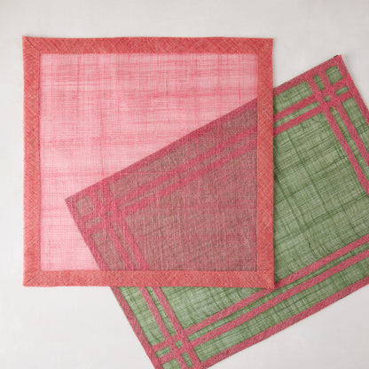 Newport Pink Square Abaca Placemat with dark pink border, partially overlapping a green placemat.