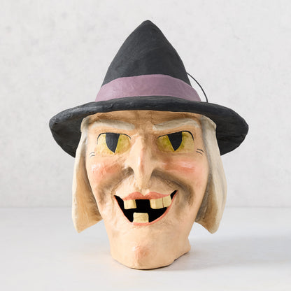 Vintage-style papier-mâché witch candy bucket with a black hat, yellow eyes, and distressed finish, 12 inches tall.