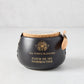 Black artisanal ceramic pot of Fleur De Sel salt with a natural cork lid and small wooden spoon.