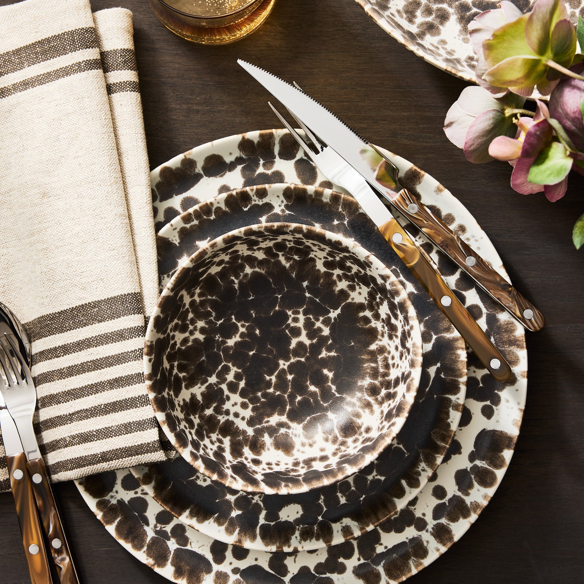 Nuno Splatter stoneware dinner plate with brown spots on cream, stacked with matching bowl and salad plate.