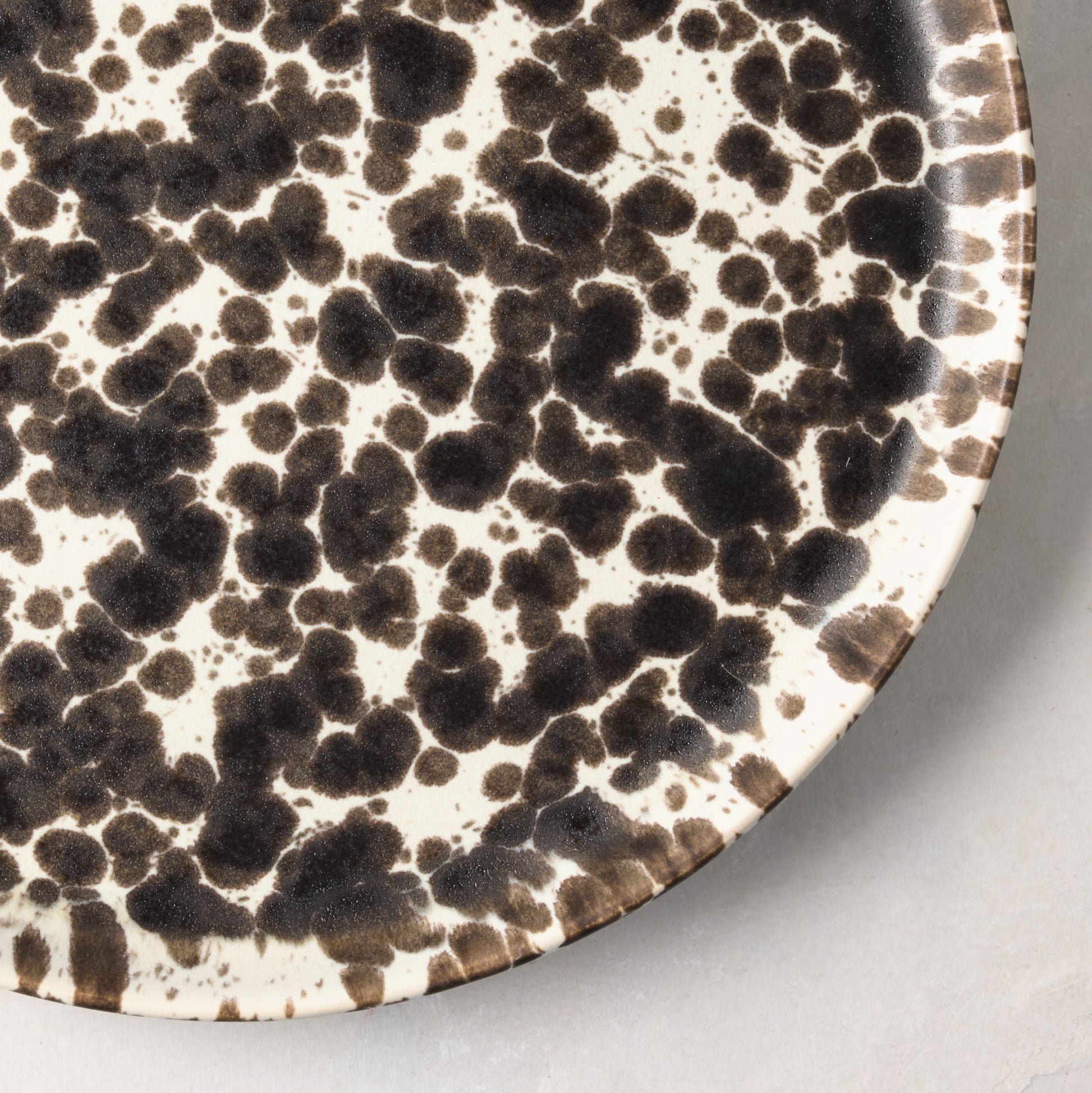Nuno Splatter 11" stoneware dinner plate with unique brown spots on a pale cream base.