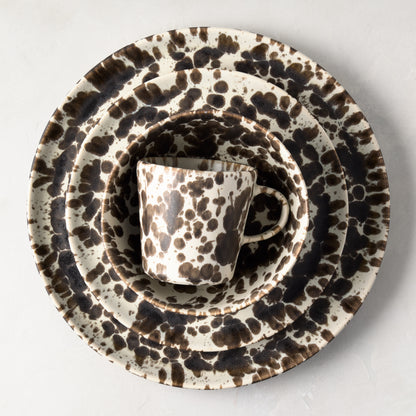 Nuno Splatter stoneware dinner plate set with brown spots on cream, including a mug, bowl, and two plates.