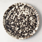 Nuno Splatter 11" stoneware dinner plate with unique brown spots on a pale cream base.