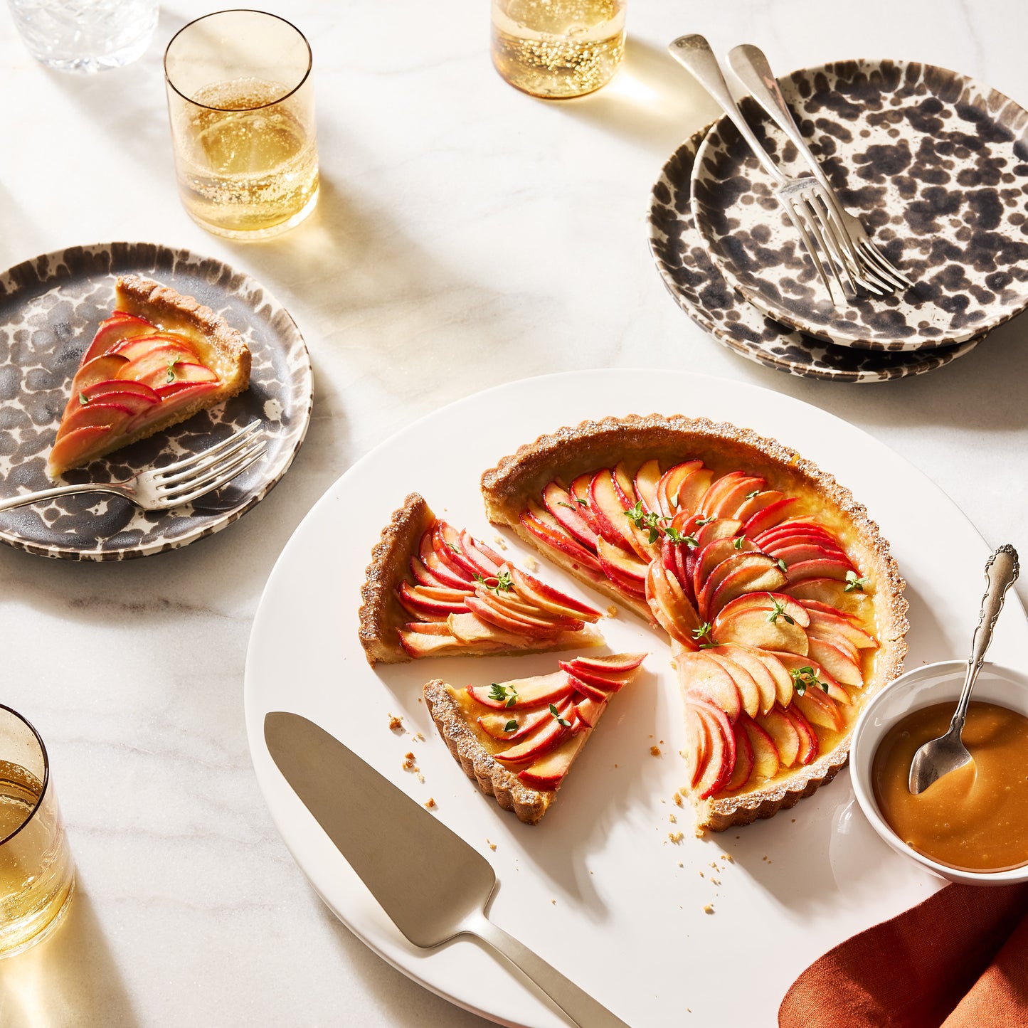 Nuno Splatter Stoneware Salad Plate with unique brown splatter on a pale cream base, holding a tart slice.