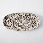 Nuno Splatter oval stoneware serving platter, pale cream with unique brown splatter design.