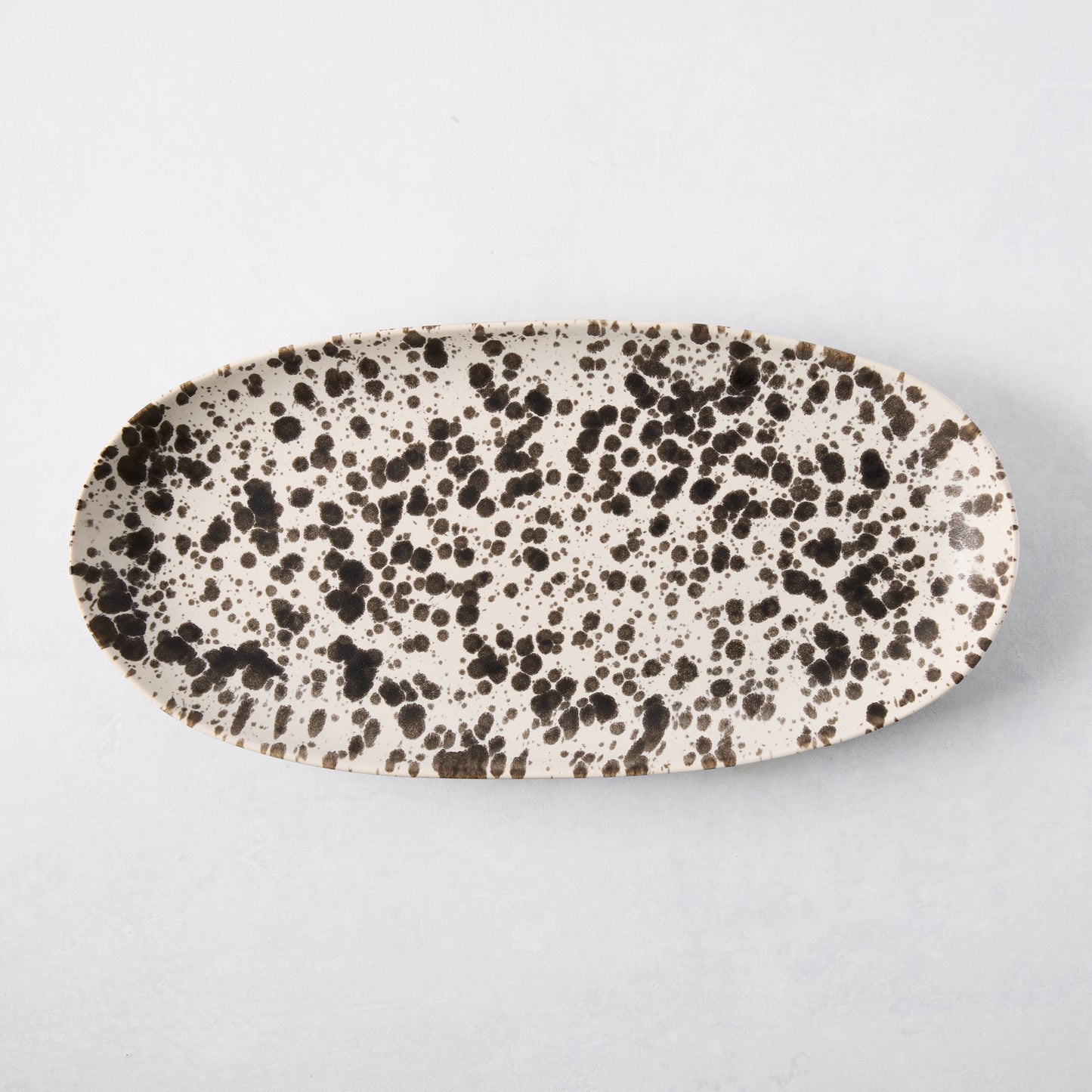 Nuno Splatter oval stoneware serving platter, pale cream with unique brown splatter design.