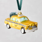 5-inch mouth-blown glass NYC taxi cab Christmas ornament with hand-painted yellow finish, glitter accents, and mini tree.