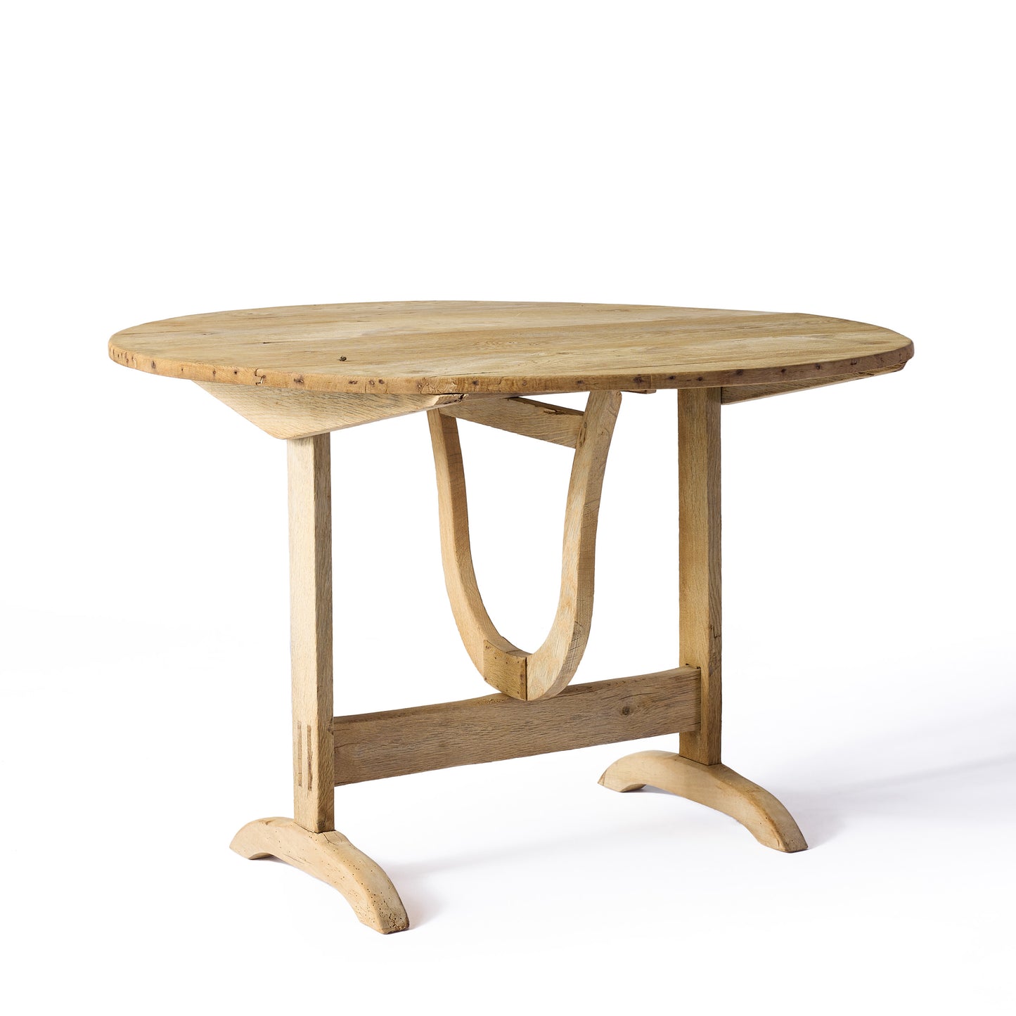 Vintage bleached oak wine tasting table with a round top and unique trestle base, featuring a rustic, worn finish.