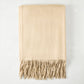 Folded Oat Cashmere Throw Blanket with classic fringe.