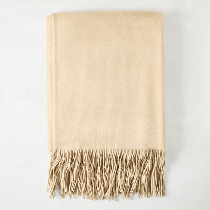 Folded Oat Cashmere Throw Blanket with classic fringe.