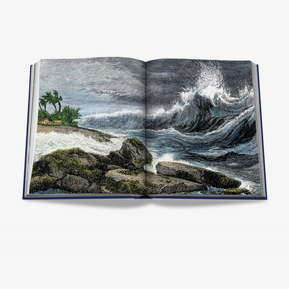 Open "Ocean Wanderlust" book, blue linen hardcover, displaying a vintage illustration of crashing ocean waves and a palm-lined shore.