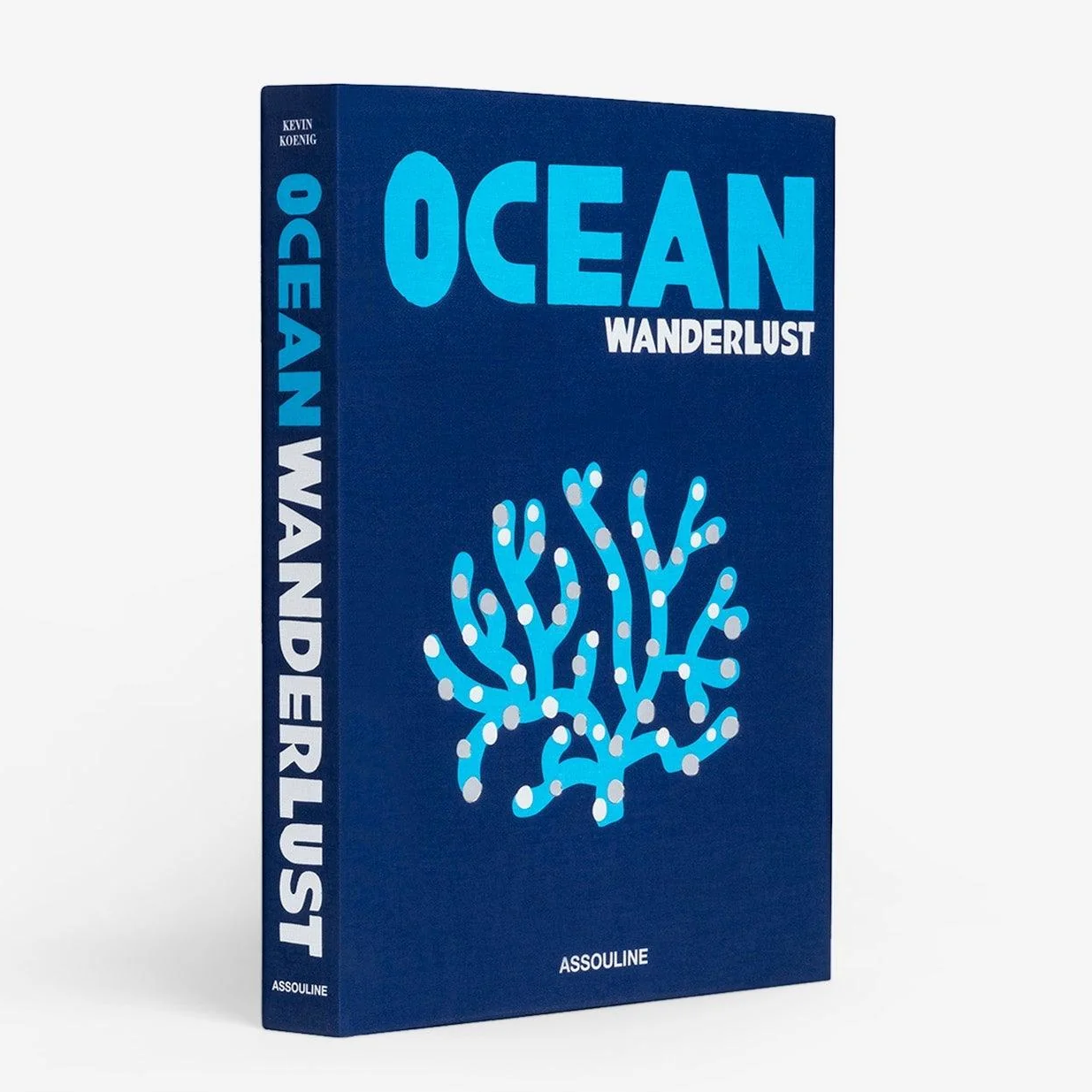 Ocean Wanderlust" book: navy blue linen hardcover with light blue and silver coral illustration.