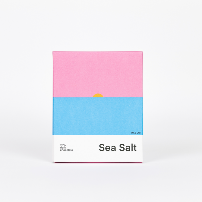 Ocelot Sea Salt Dark Chocolate bar with pink, blue, and white packaging, featuring a yellow sun graphic.