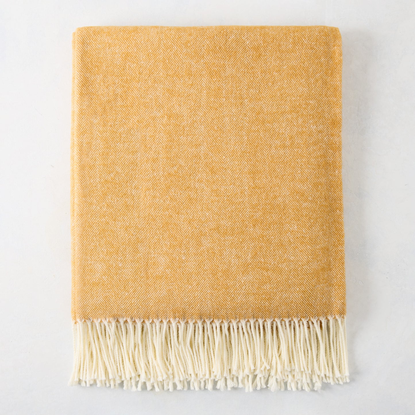 Ochre yellow Italian herringbone throw blanket with decorative fringe, 51"W x 67"L, cotton-acrylic blend.