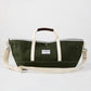 Olive green canvas garden tote bag with cream straps, brown leather handle grips, and a gray interior lining.