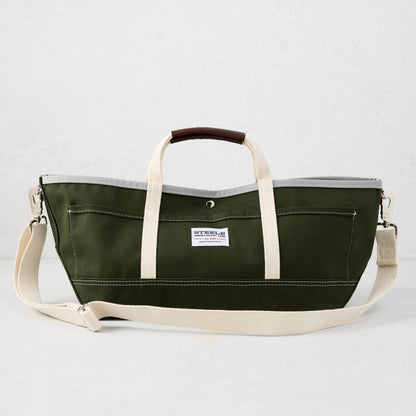 Olive green canvas garden tote bag with cream straps, brown leather handle grips, and a gray interior lining.