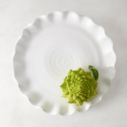 White Onda Round Ceramic Serving Platter with ruffled edge, 20"Dia, holding a green Romanesco broccoli.