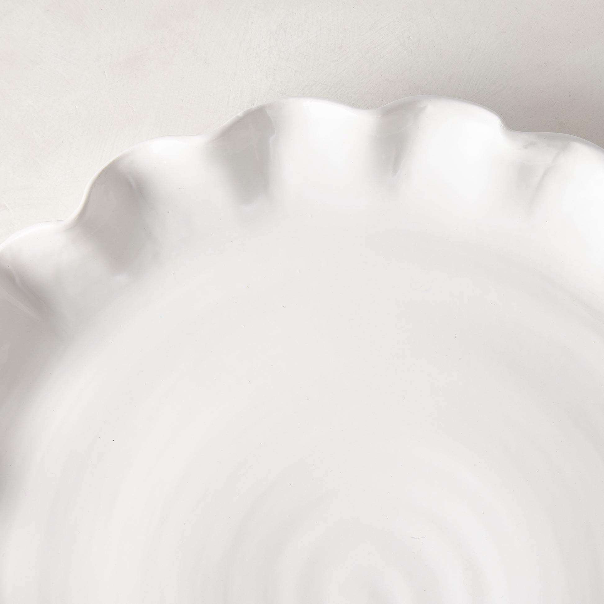 White Onda Round Ceramic Serving Platter with wavy, ruffled edge.