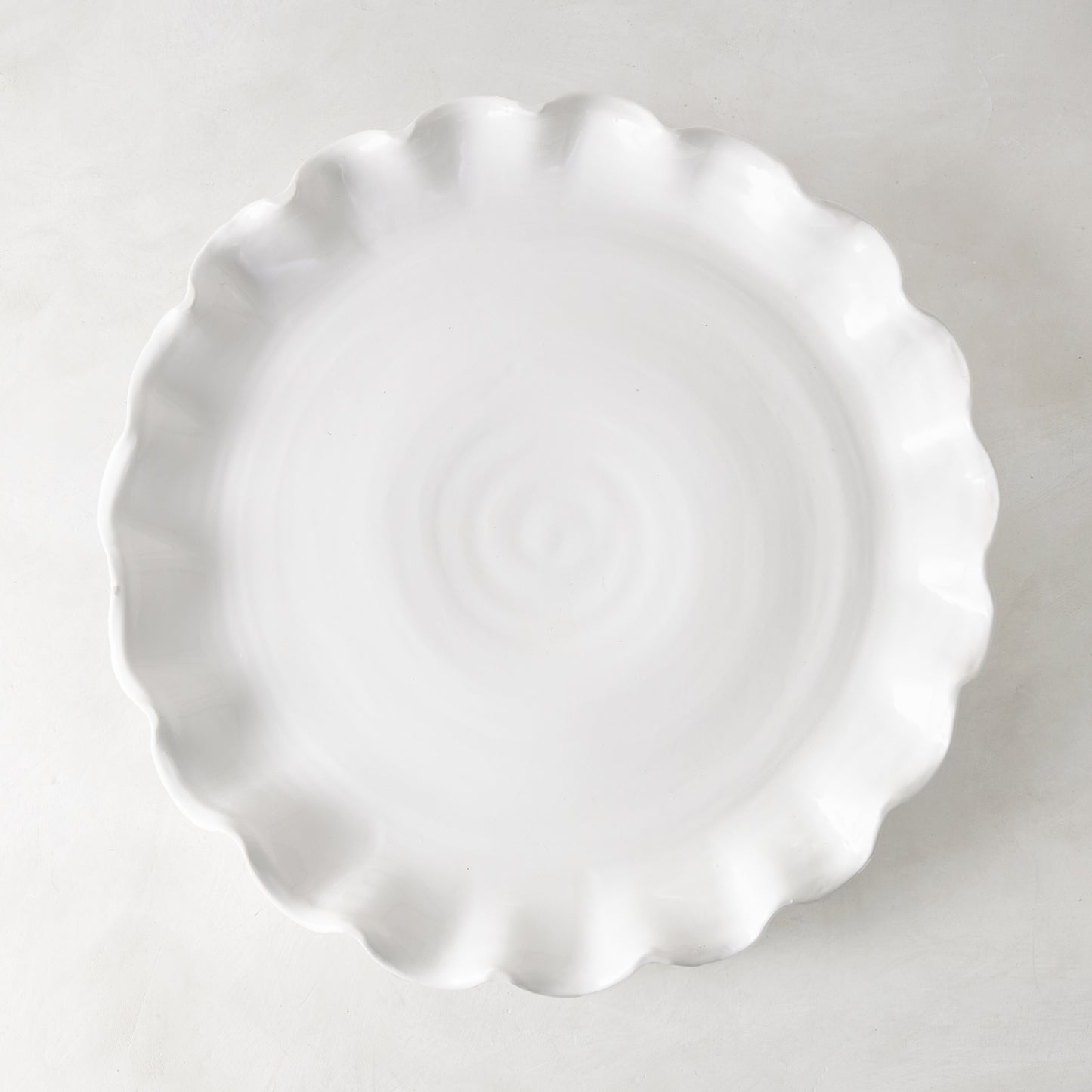 White Onda Round Ceramic Serving Platter, 20"Dia, with a playful ruffled edge.