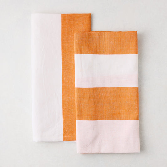 Set of 2 orange and white block print cotton-linen hand towels; one half-and-half, one striped.