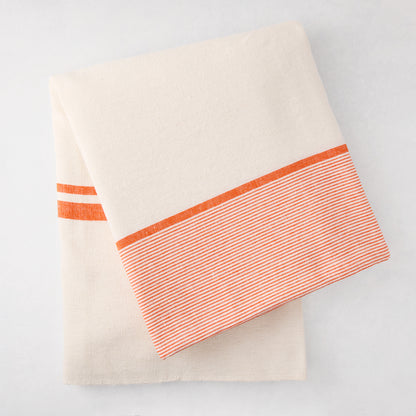 Folded Orange Boat Stripe Tablecloth, 70"x108" cotton-linen blend, with thick and thin orange stripes.