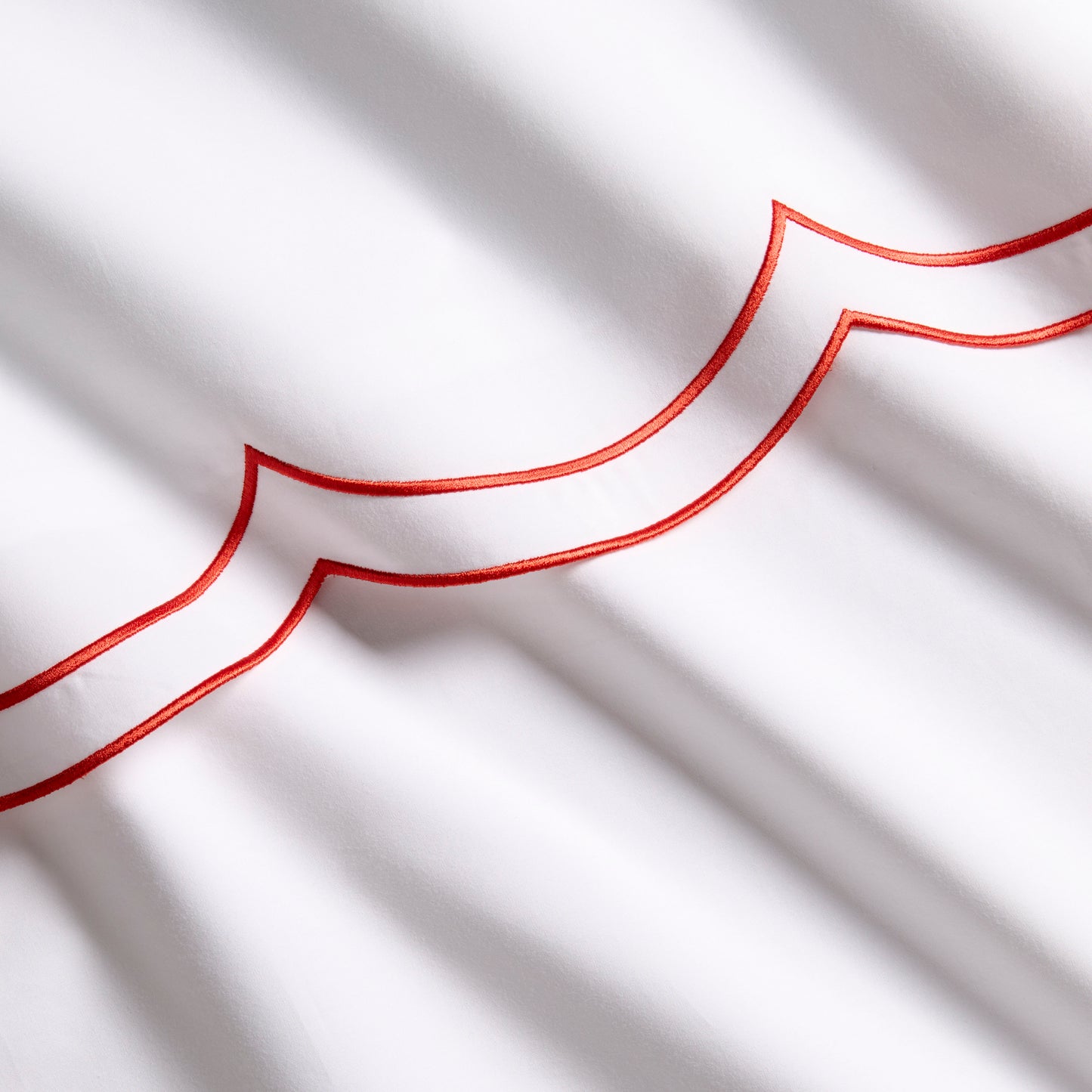 White percale sheet with orange double scallop stitch embroidery.