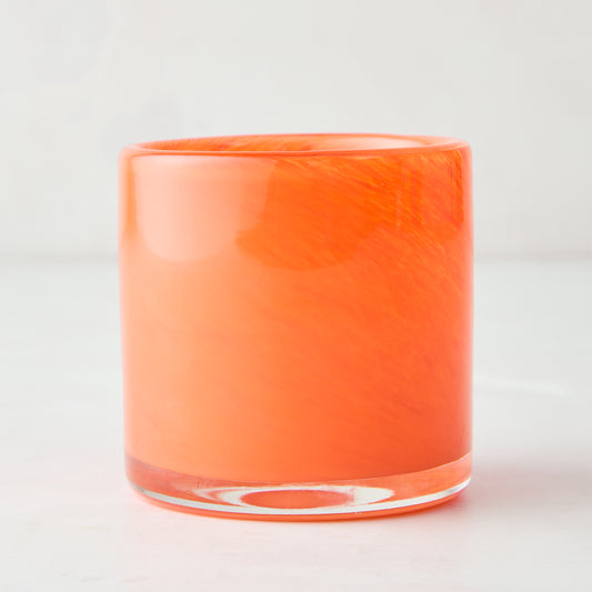 Mouth-blown, hand-formed orange glass votive candle holder with subtle swirl pattern, 2.75"H.