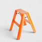 Hudson Grace orange Hasegawa Lucano 2-step ladder with a matte finish, grooved treads, and a sturdy metal frame.