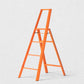 Hudson Grace orange Hasegawa Lucano 4-step ladder with a minimalist aluminum and steel design and safety bar