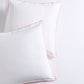 Set of 2 white percale Euro shams with orange piping and double-stitch detailing.
