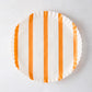 Round white parchment liner with vertical orange stripes and ruffled edges.