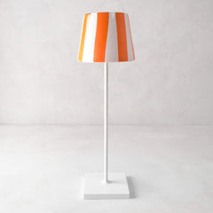Hand-painted ceramic lamp shade with orange and white stripes on a white Poldina Pro lamp base.