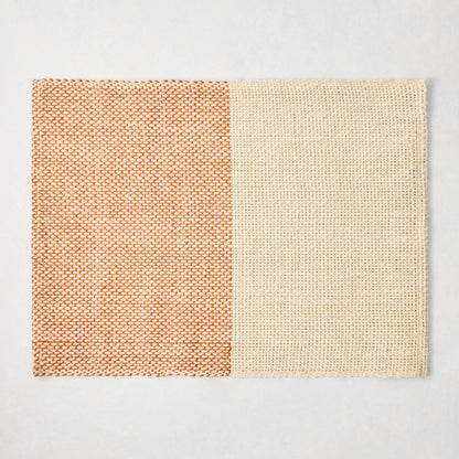 Orange and beige woven abaca and jute rectangular placemat with half and half pattern, 19"W x 14"L.