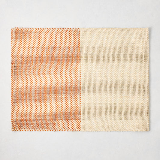 Orange and beige woven abaca and jute rectangular placemat with half and half pattern, 19"W x 14"L.