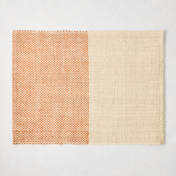 Orange and beige woven abaca and jute rectangular placemat with half and half pattern, 19"W x 14"L.