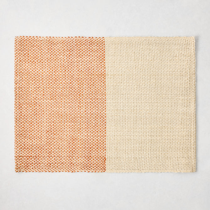 Orange and beige woven abaca and jute rectangular placemat with half and half pattern, 19"W x 14"L.