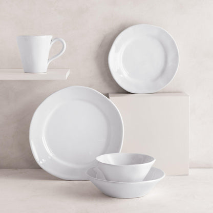 Creamy white ceramic dinnerware set: 11.5" dinner plate, salad plate, mug, and two bowls with organic edges.