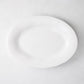 Creamy white oval ceramic serving platter with subtle organic edges.