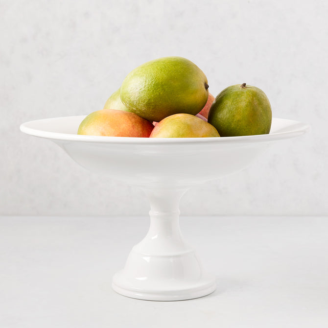 HG Original 15" Dia x 9" H creamy white ceramic pedestal serve bowl filled with fruit.